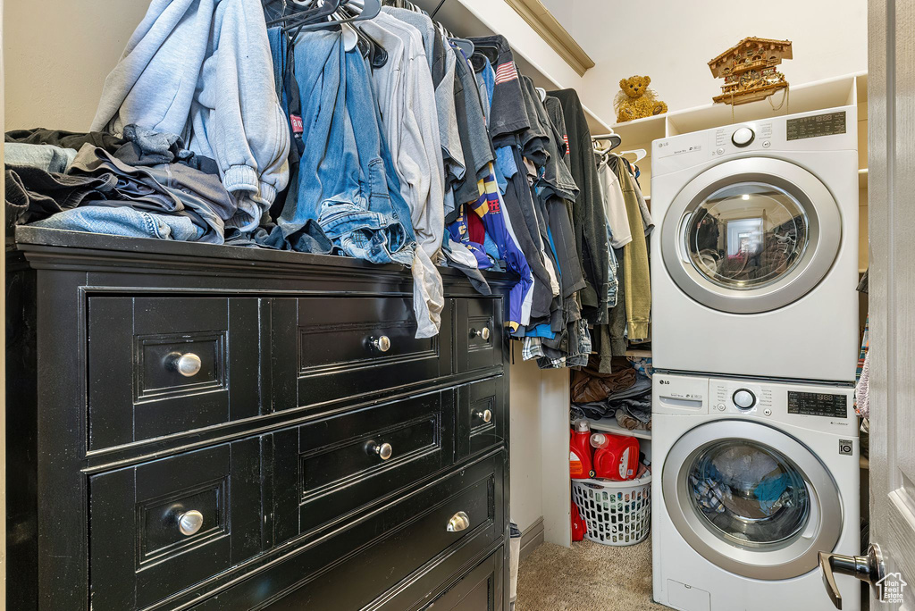 Laundry area with stacked washer / dryer and carpet floors