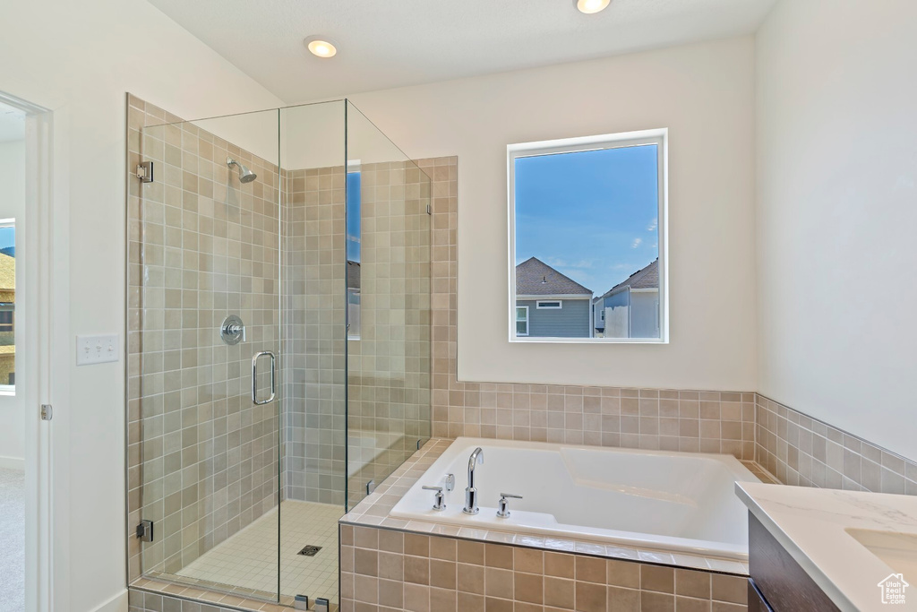 Bathroom featuring a garden tub, a shower stall, vanity, and recessed lighting