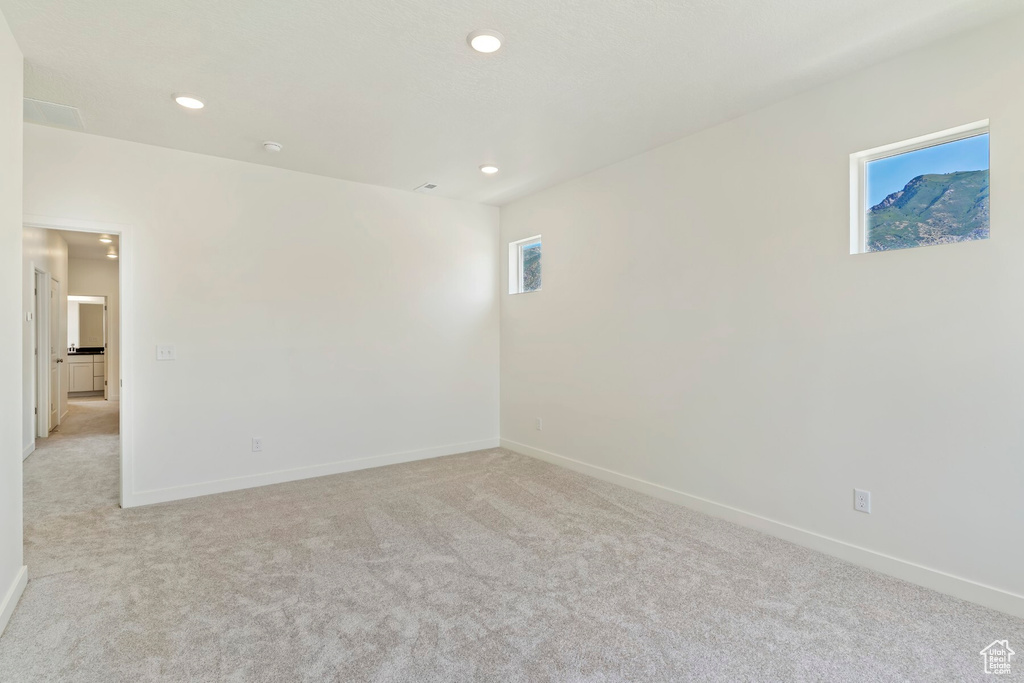 Unfurnished room with light colored carpet and recessed lighting