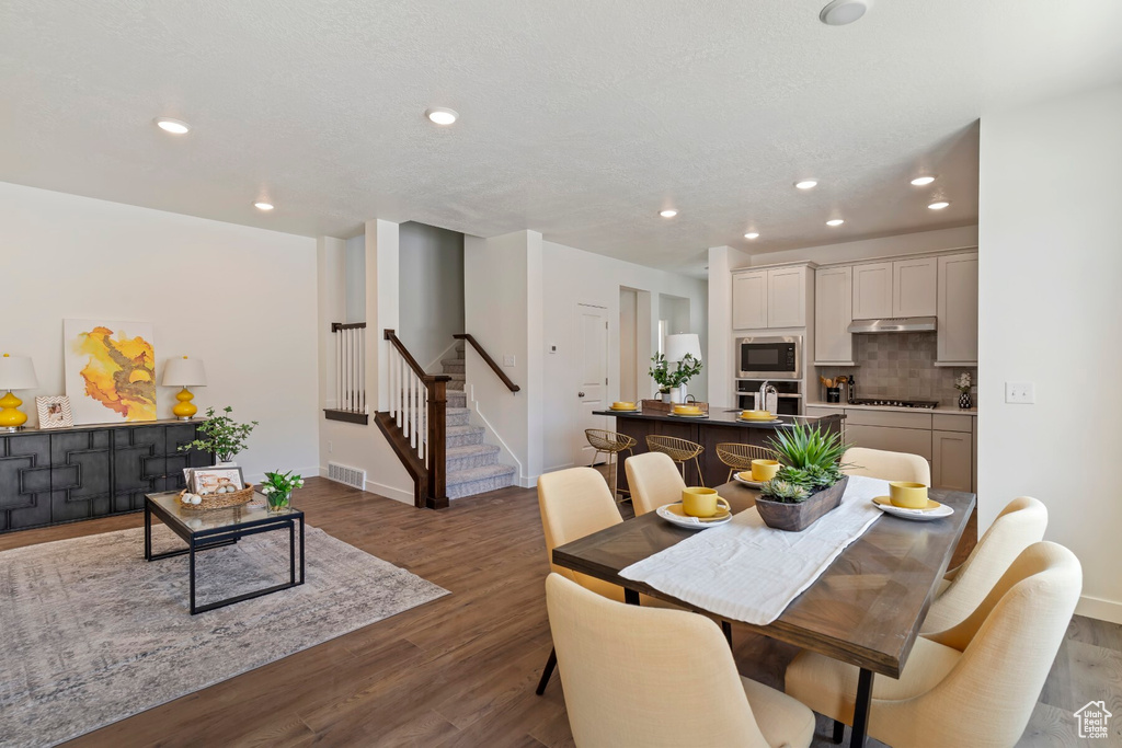 Dining room featuring stairway, wood finished floors, and recessed lighting