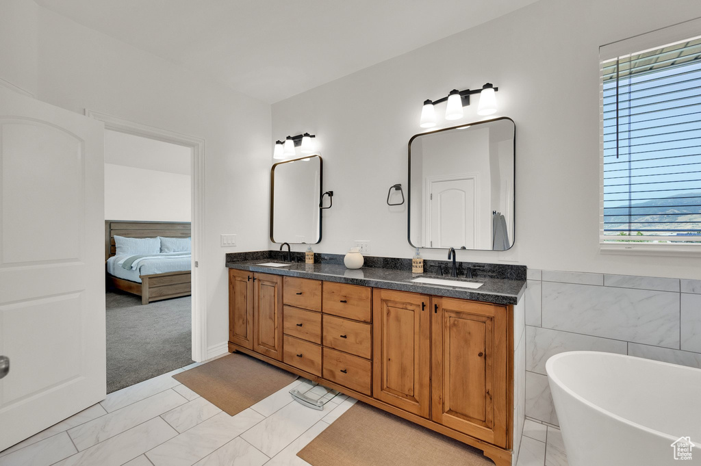 Full bathroom with double vanity, a soaking tub, and ensuite bath