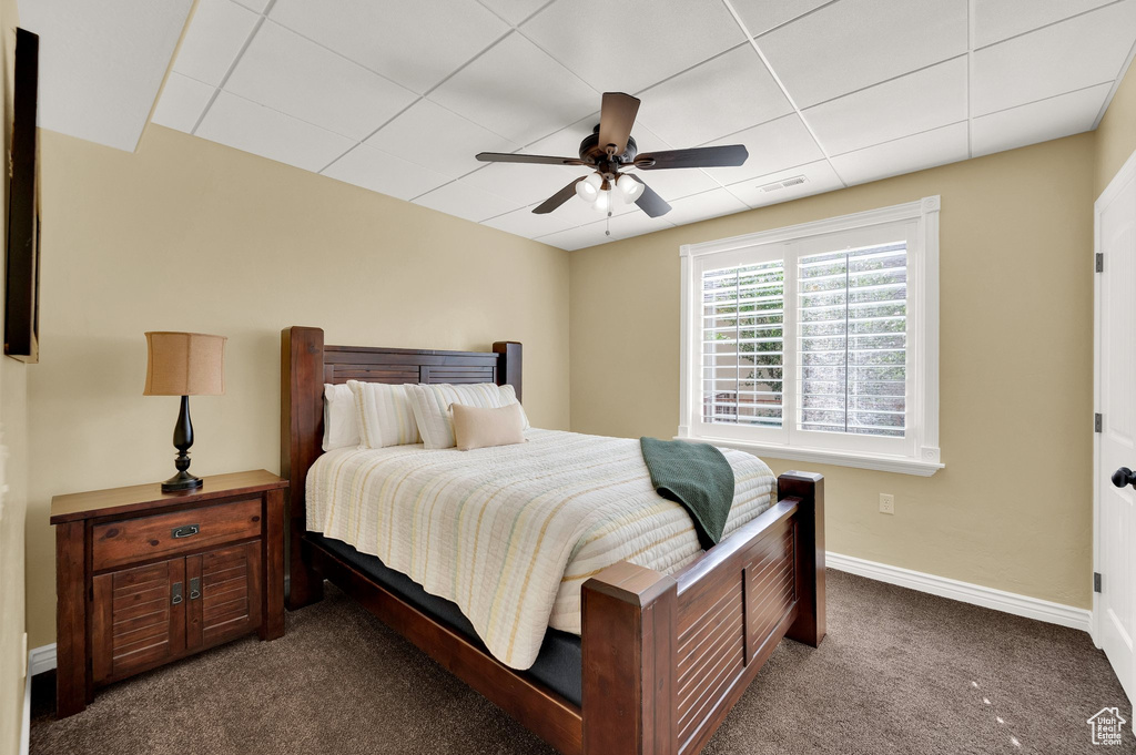 Carpeted bedroom with baseboards and a ceiling fan