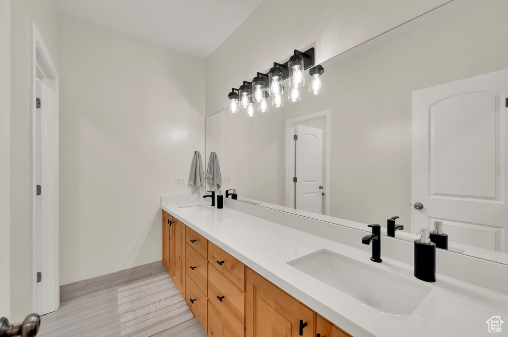 Full bathroom with double vanity and baseboards