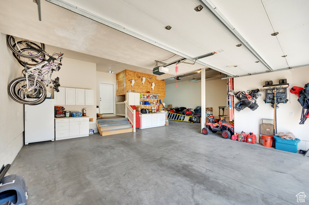Garage with freestanding refrigerator and a garage door opener