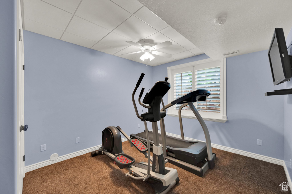 Workout area with ceiling fan and carpet