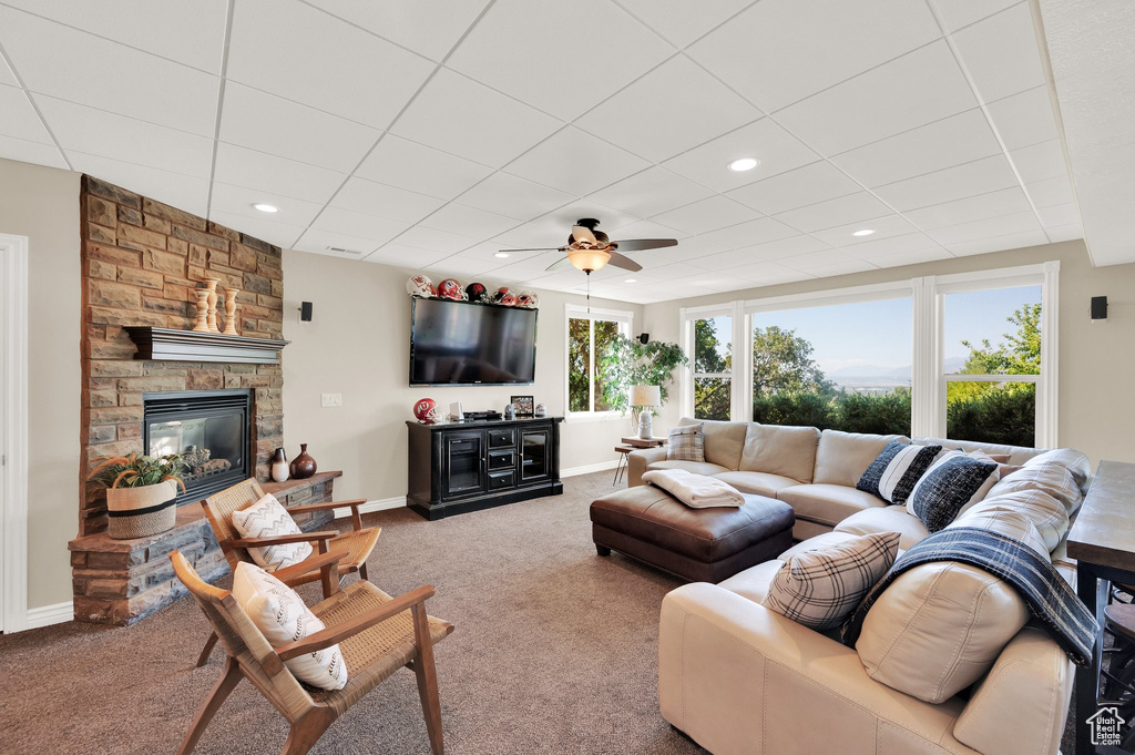 Living room with carpet flooring, ceiling fan, a fireplace, and recessed lighting