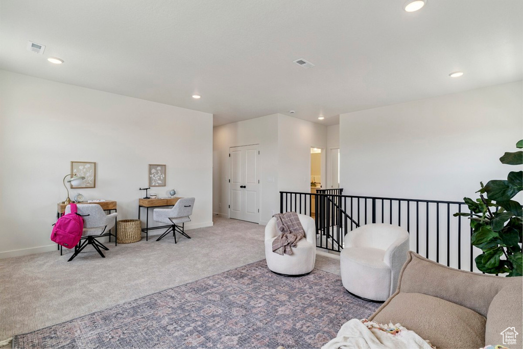 Sitting room featuring carpet, recessed lighting, and an upstairs landing