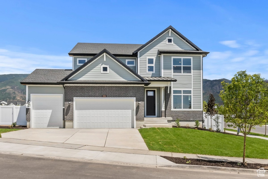 View of front facade with a garage, brick siding, and a mountain view