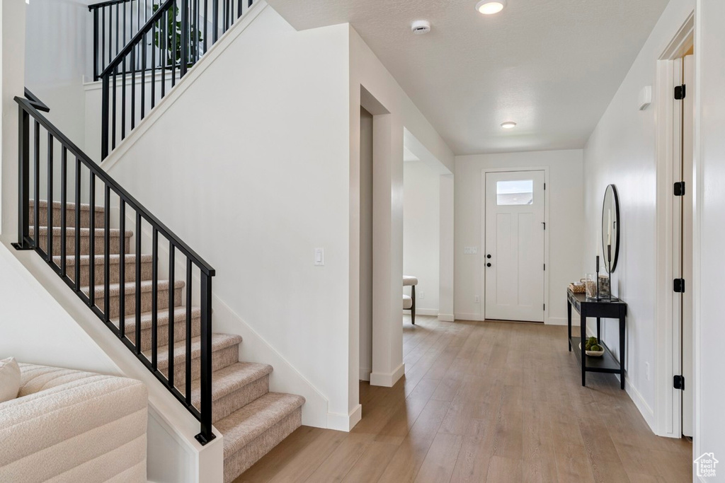 Foyer entrance featuring light wood-style floors, stairs, and recessed lighting