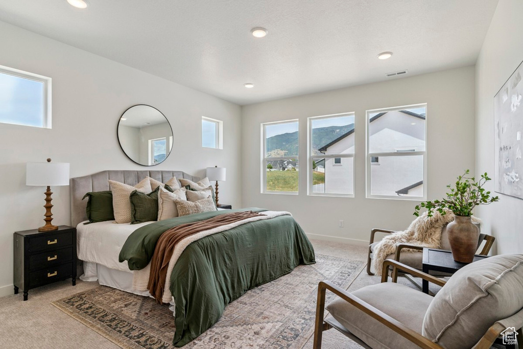 Bedroom featuring light carpet, multiple windows, and recessed lighting