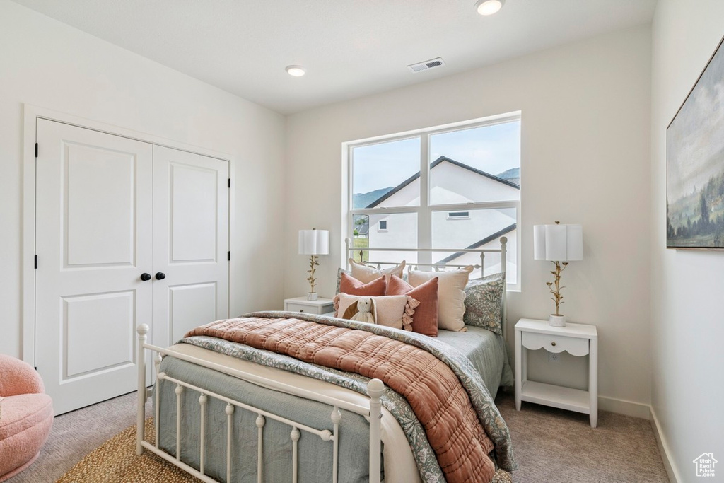 Bedroom featuring light colored carpet and a closet