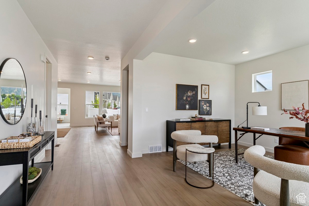 Living room featuring plenty of natural light, wood finished floors, recessed lighting, and an office area