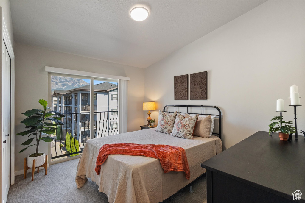 Bedroom featuring vaulted ceiling, access to outside, and carpet