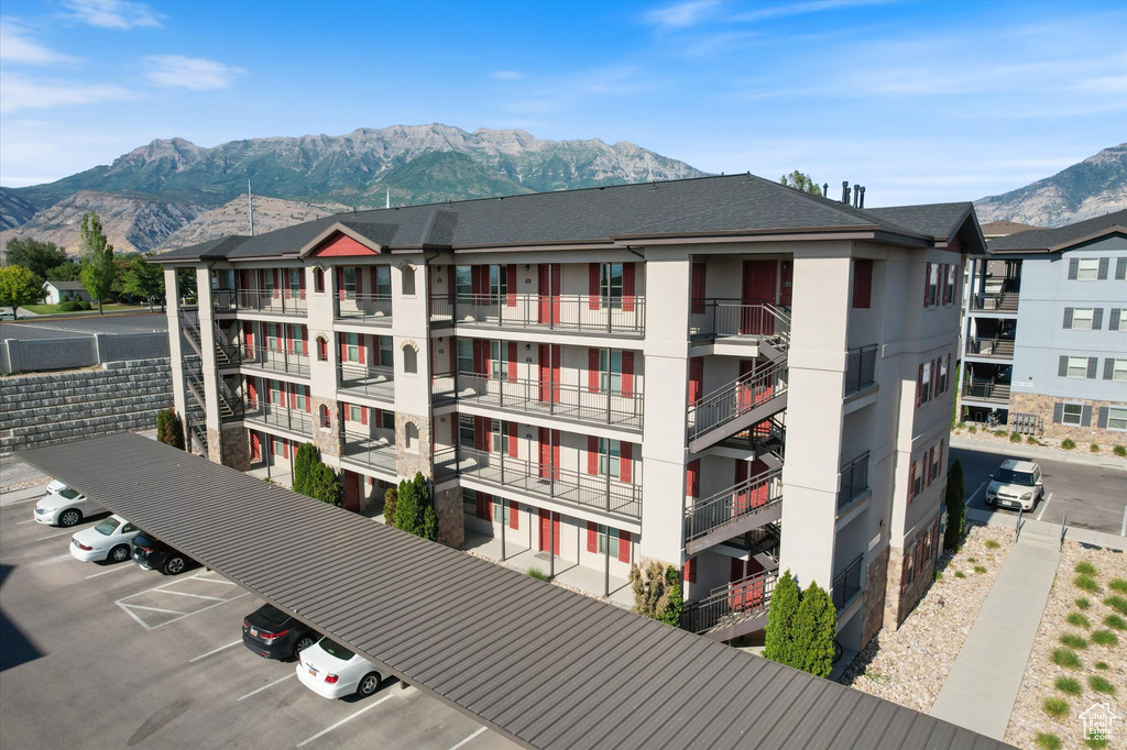 View of apartment building / complex with uncovered parking and a mountain view