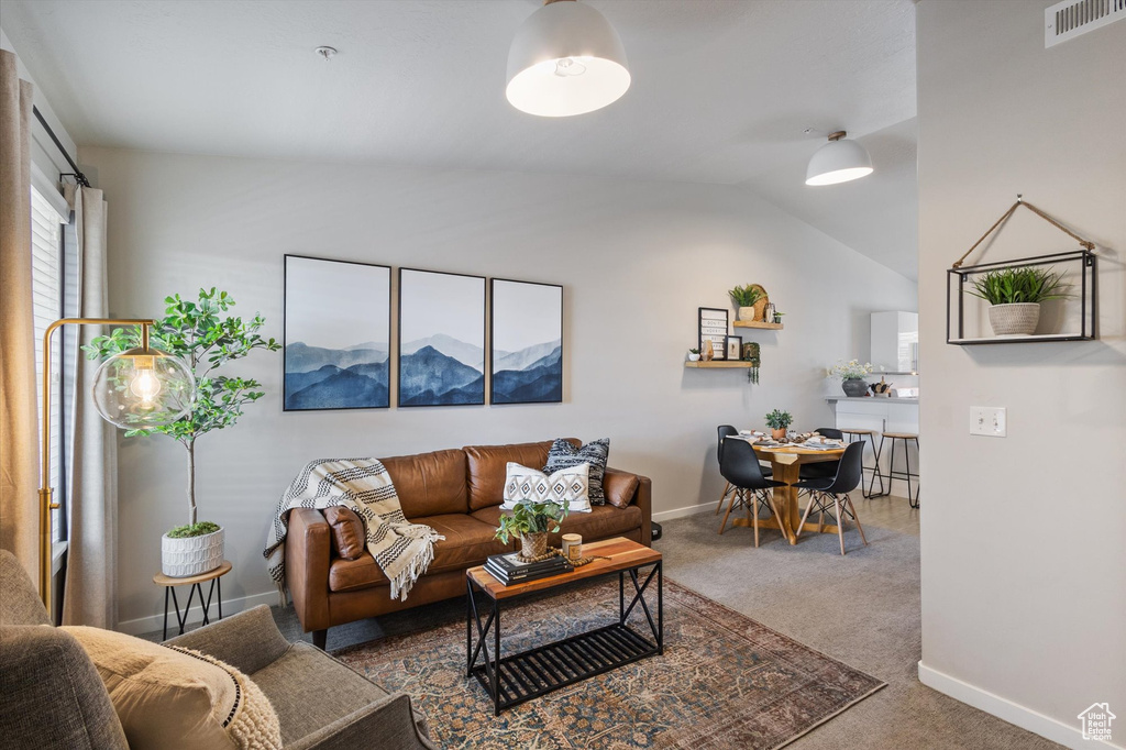 Living area featuring carpet floors and lofted ceiling