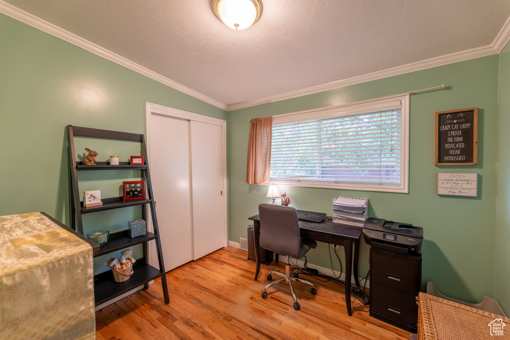Home office featuring ornamental molding and wood finished floors