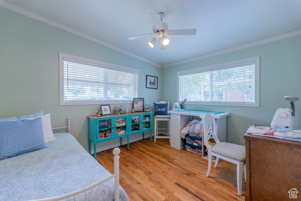 Bedroom featuring ornamental molding, light wood-style flooring, and ceiling fan