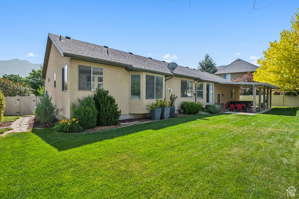 Back of house with a patio area, a gate, and stucco siding