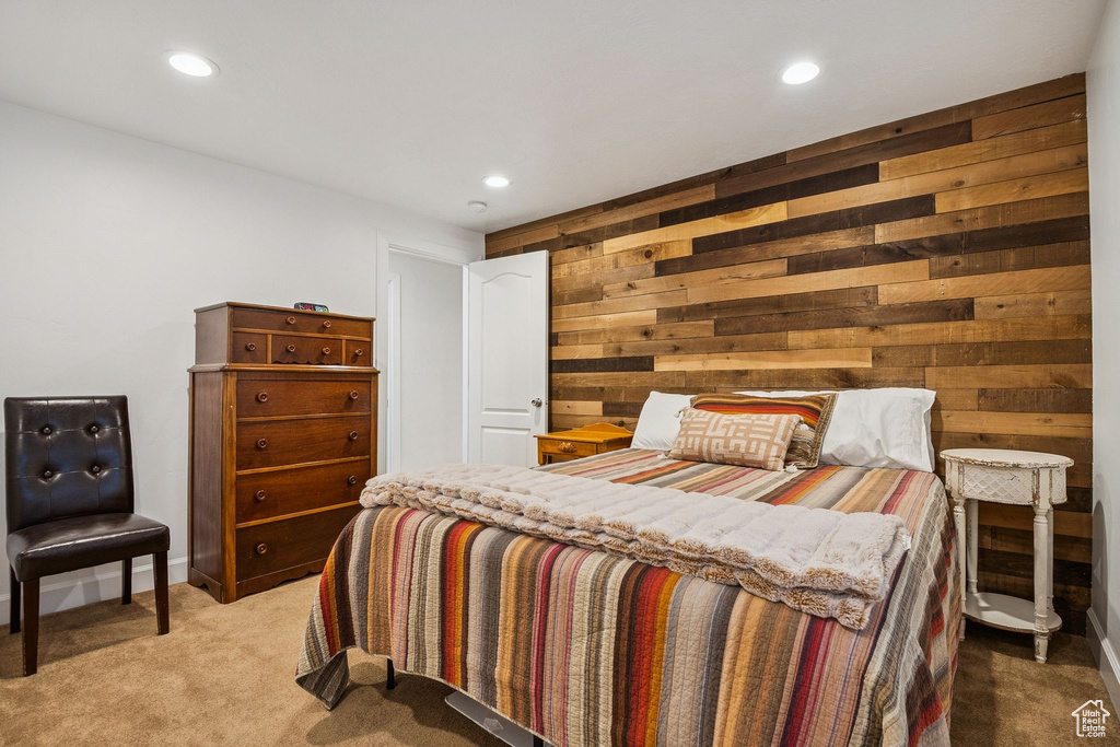 Bedroom with wood walls, recessed lighting, and light carpet