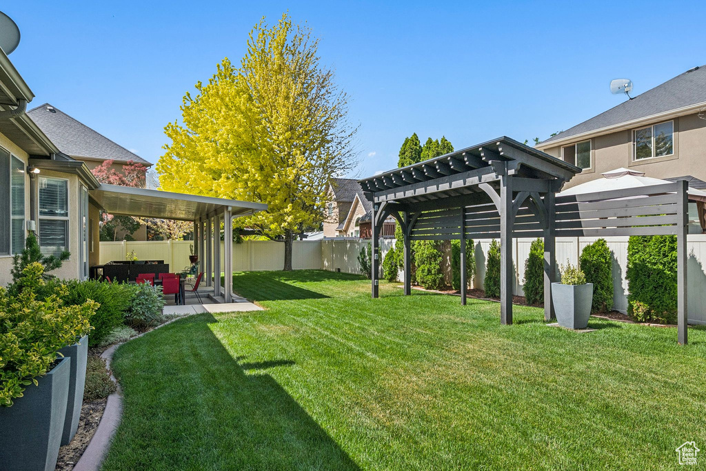 Fenced backyard featuring a pergola and a patio area