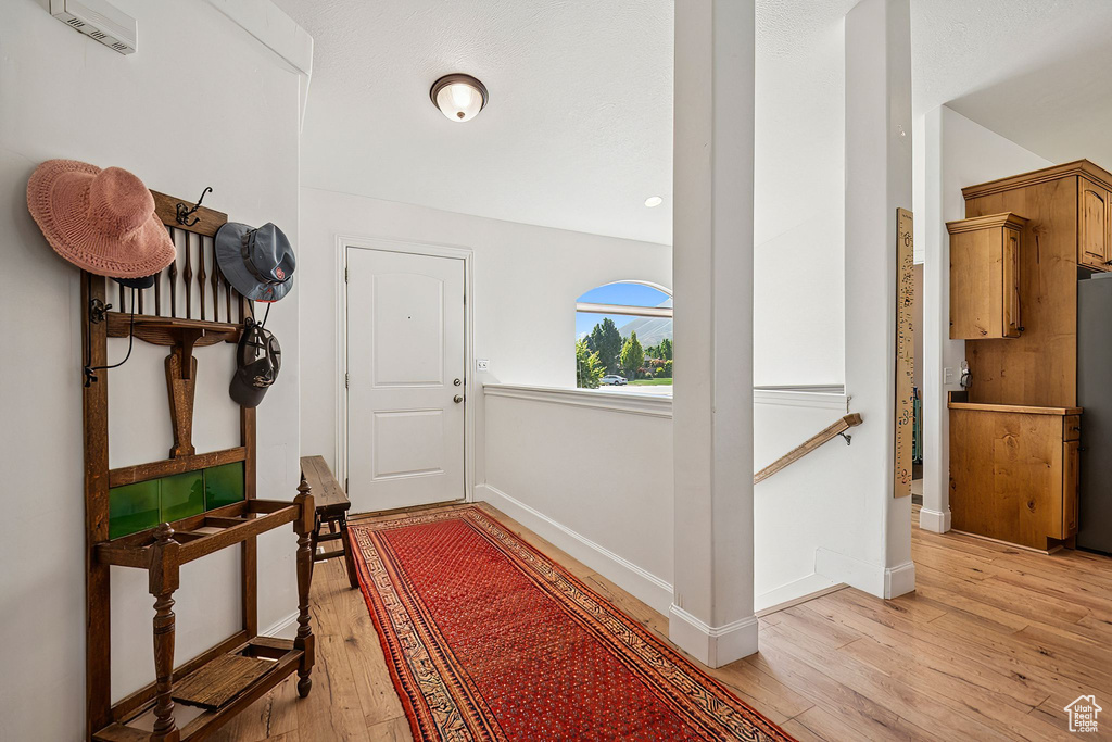 Doorway to outside with light wood-style floors and baseboards