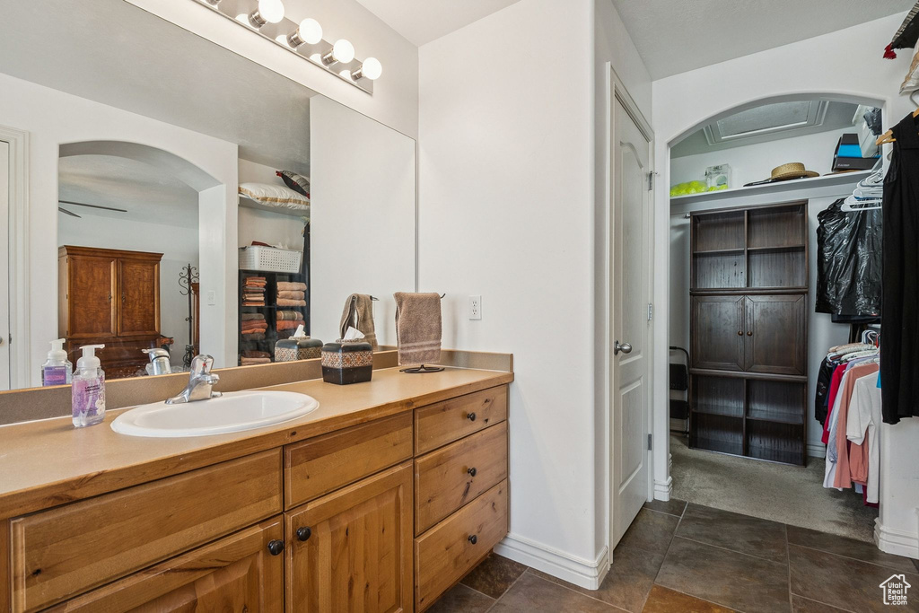 Bathroom featuring vanity, a spacious closet, and tile patterned floors