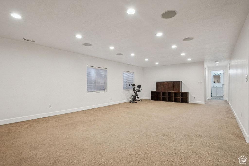 Below grade area with light carpet and recessed lighting