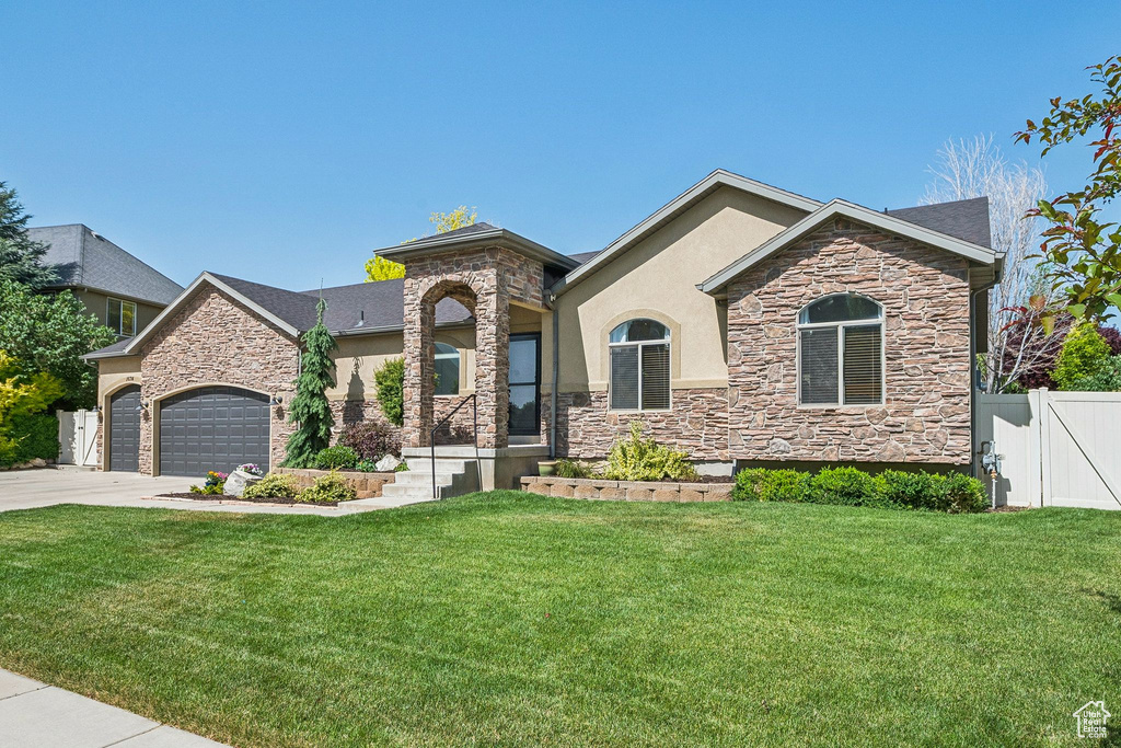 View of front of home featuring stone siding, stucco siding, driveway, and a garage