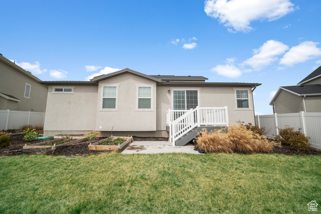 Back of property featuring a garden and stucco siding