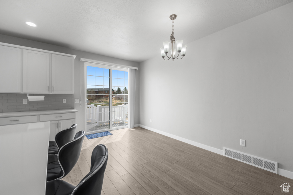 Dining room with a chandelier, light wood-style floors, and an office area