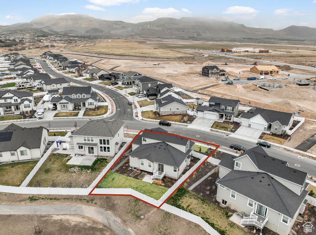 Aerial view of residential area featuring a mountain backdrop and property parcel outlined