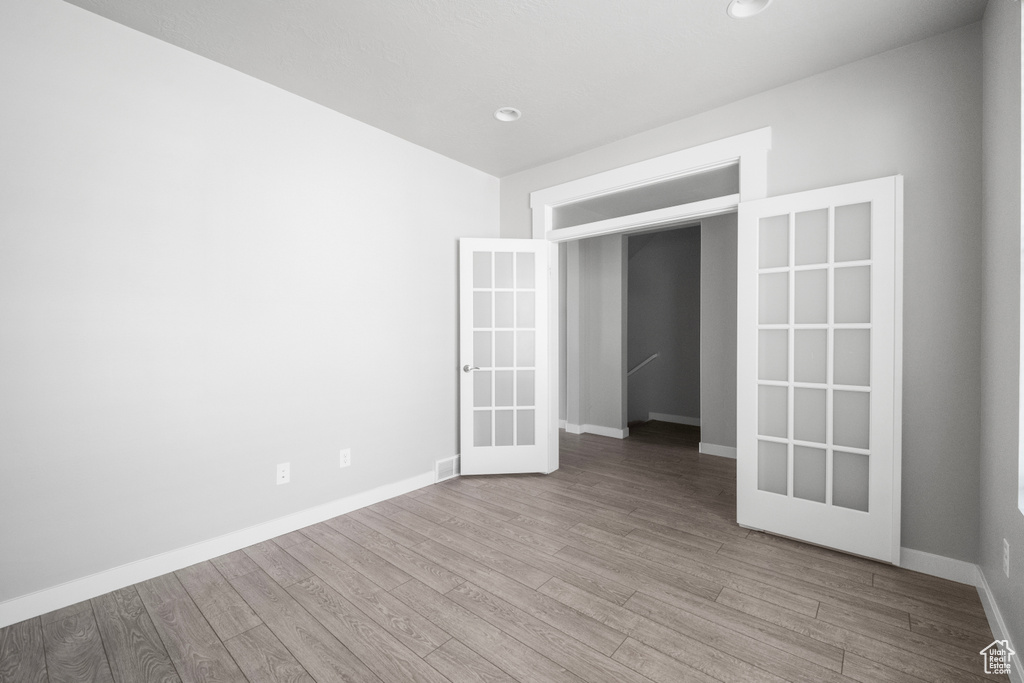 Spare room with wood finished floors and french doors