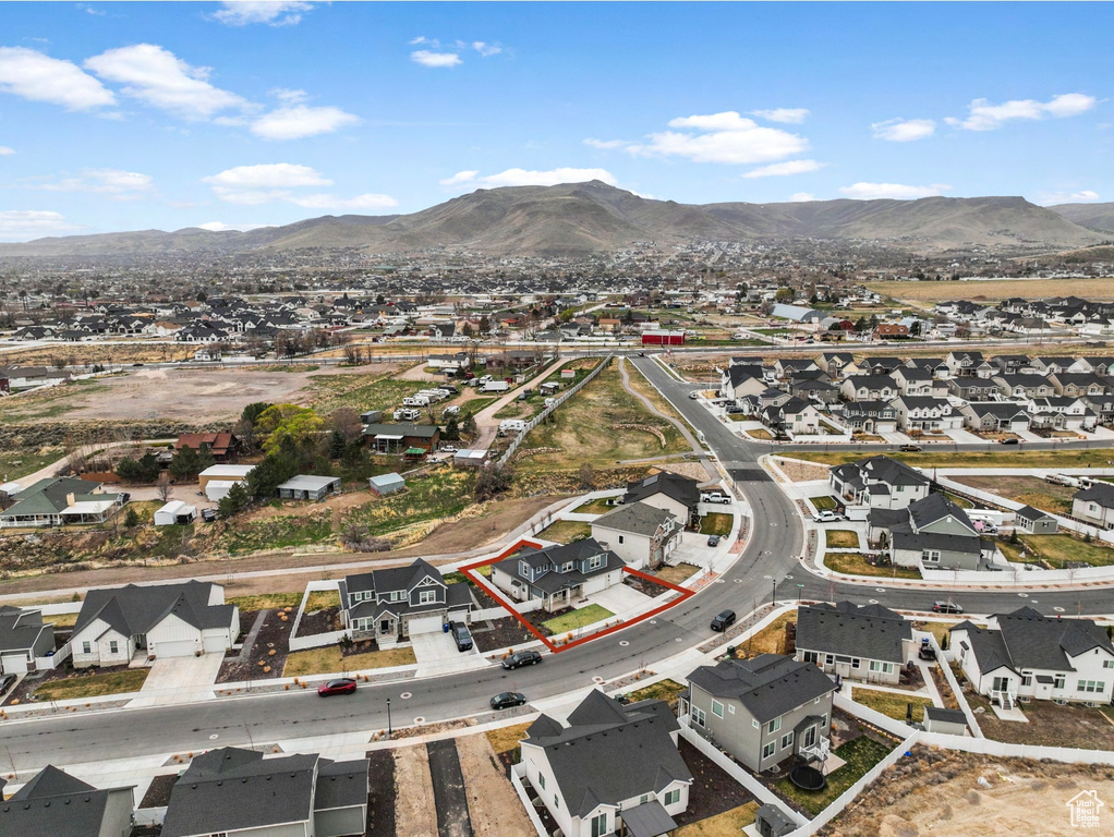 Aerial view of residential area with a mountain backdrop and property parcel outlined