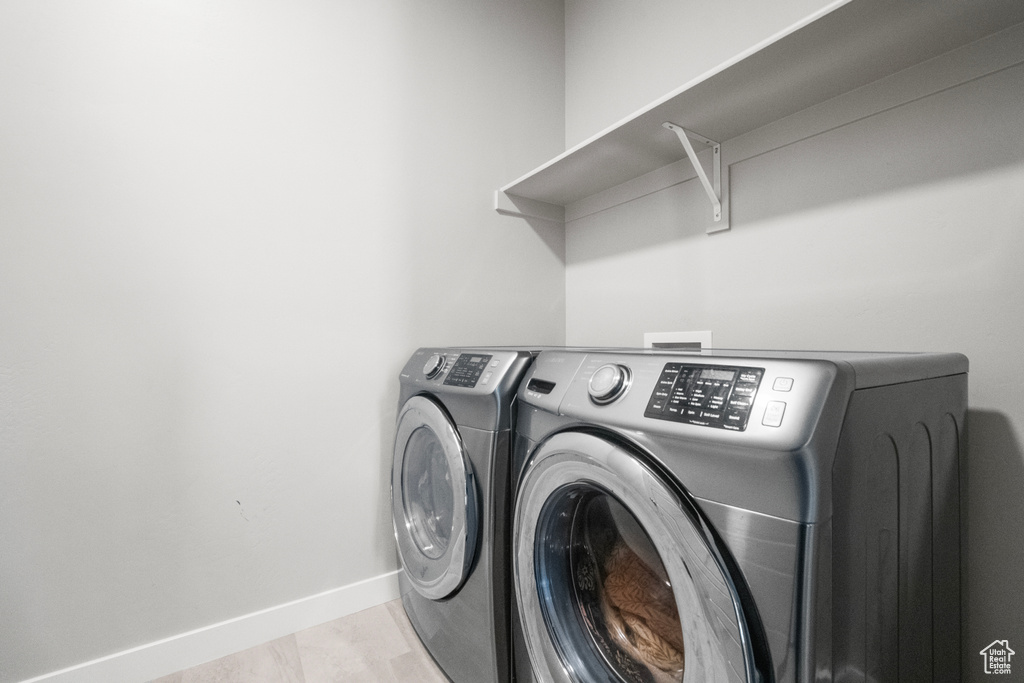 Laundry area featuring washing machine and clothes dryer and baseboards