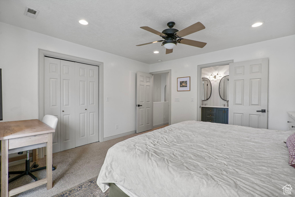 Carpeted bedroom with recessed lighting, a closet, a ceiling fan, ensuite bathroom, and a desk