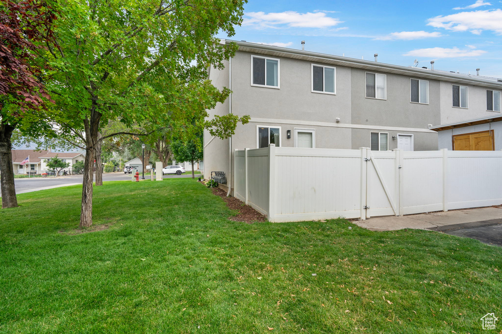 Back of house with stucco siding and a gate