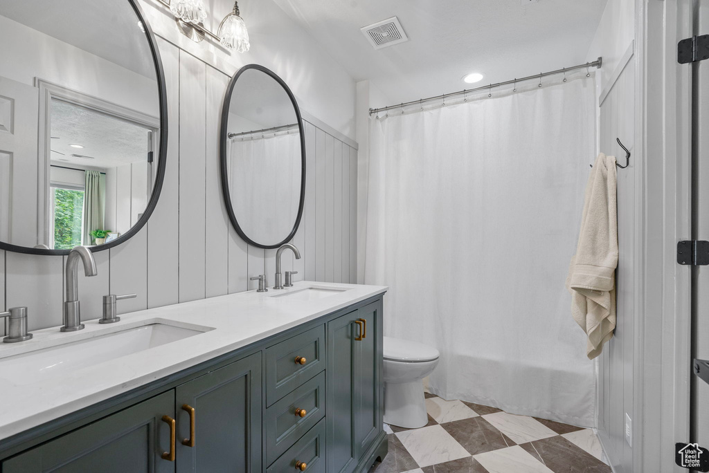 Bathroom with double vanity and a shower with curtain