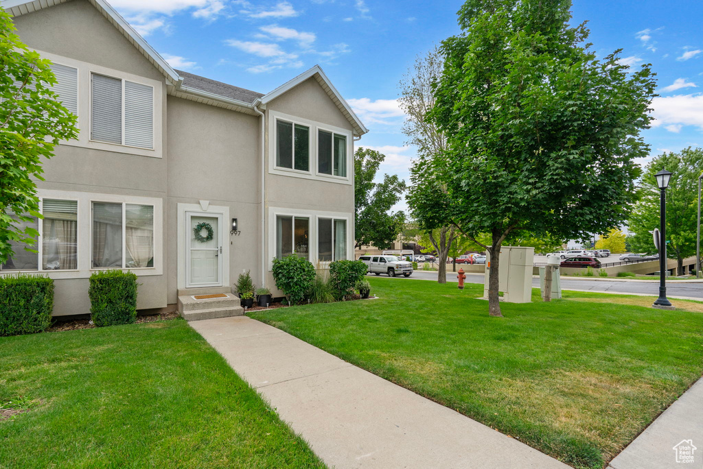 Traditional-style home featuring stucco siding and a front lawn