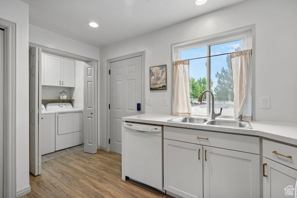 Laundry room featuring cabinet space, washer and clothes dryer, light wood finished floors, and recessed lighting