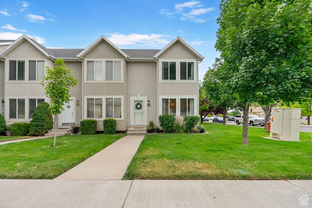 Traditional home with stucco siding and a front yard