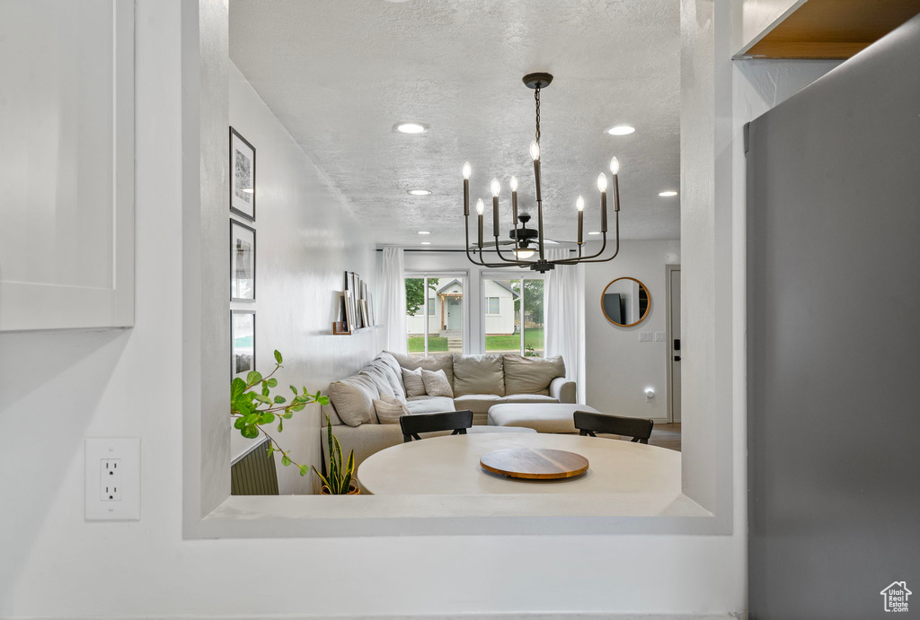 Living room with a textured ceiling, recessed lighting, and a chandelier