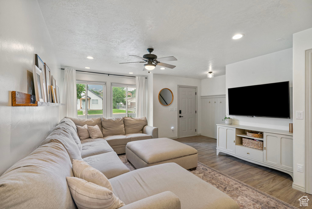 Living room featuring a ceiling fan, wood finished floors, recessed lighting, and a textured ceiling