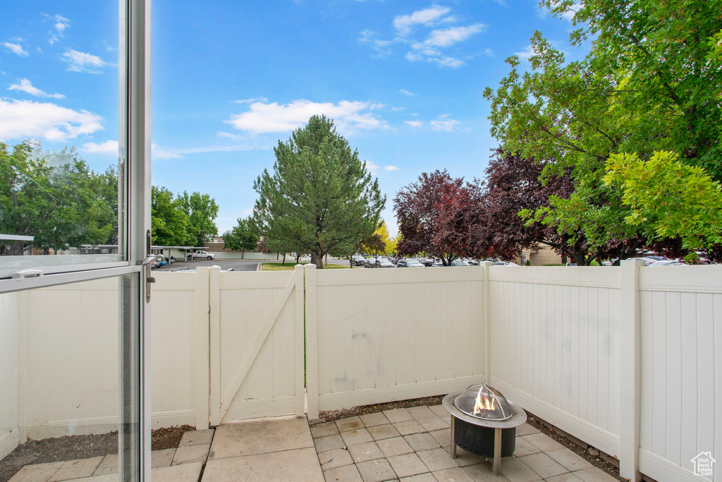 View of patio with a fire pit and a gate
