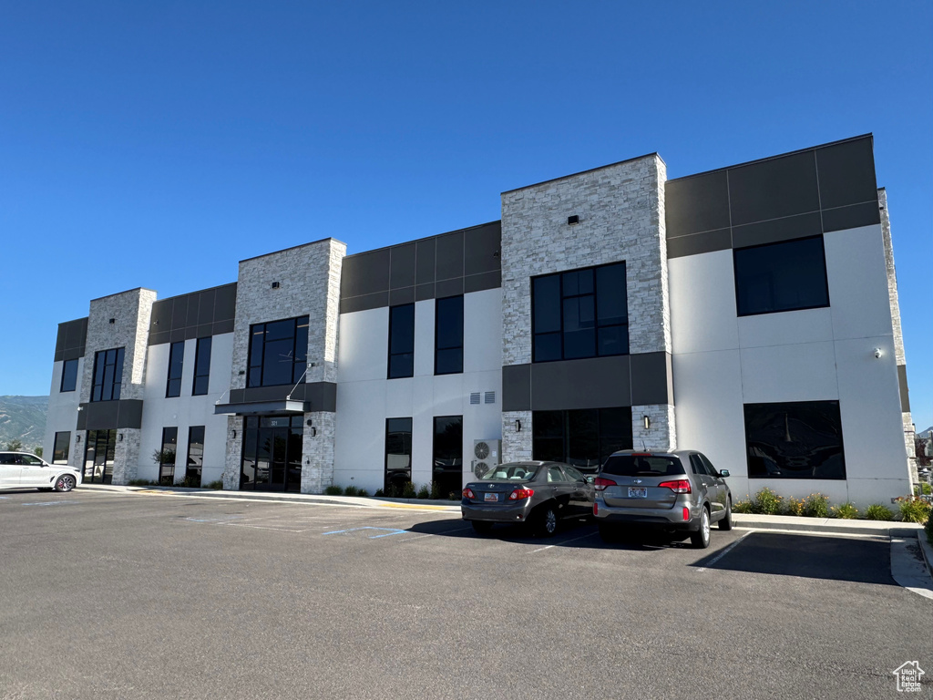 View of building exterior with uncovered parking