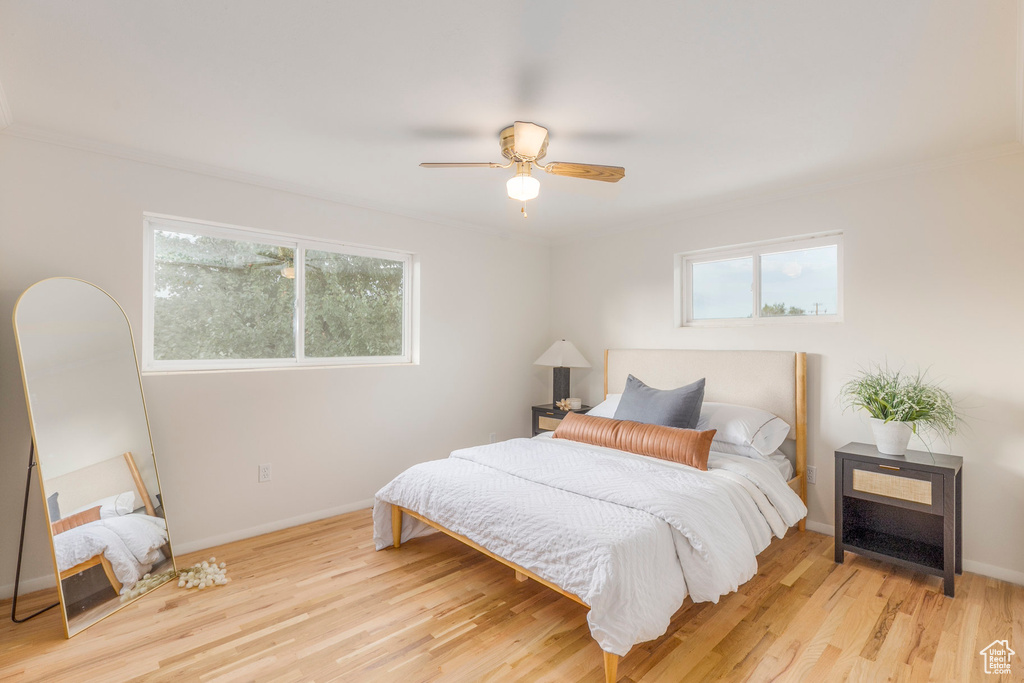 Bedroom featuring wood finished floors, ceiling fan, and crown molding