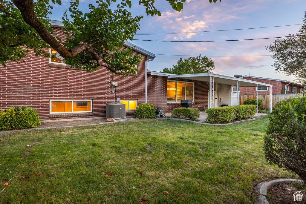 Property exterior at dusk featuring brick siding and a central AC unit