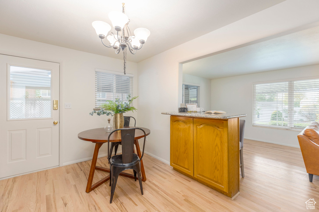 Dining space with light wood-style flooring and a chandelier