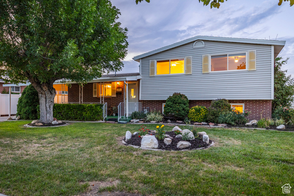 Split level home featuring a front lawn and brick siding