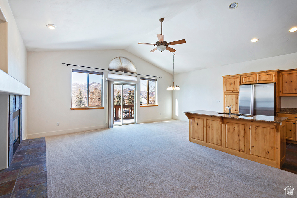 Unfurnished living room with a glass covered fireplace, a ceiling fan, lofted ceiling, carpet floors, and recessed lighting