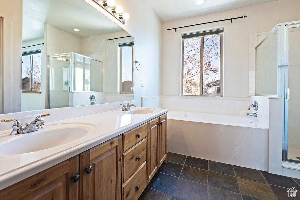 Full bathroom with a stall shower, a bath, double vanity, healthy amount of natural light, and recessed lighting